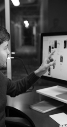A person pointing at design elements on a monitor