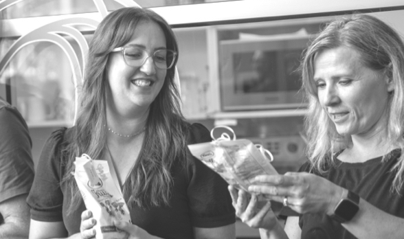 Two people smiling while inspecting packaging