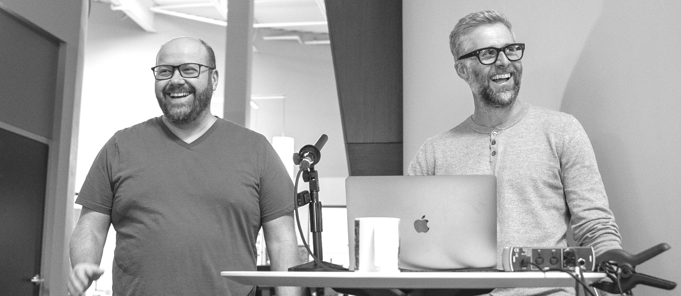 Two people grinning while giving a presentation